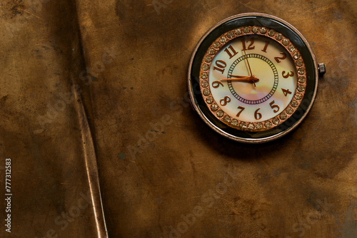 Time. Mechanical watch in a copper frame on a sheet of old antique bronze.