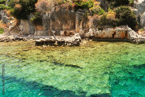 Submerged foundation in the foreground and structures and walls onshore in the background at the ancient sunken city of Kekova, Kekova Island, Demre, Turkey