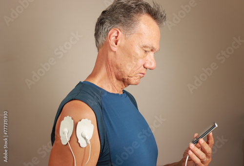 Man using an Electro Therapy Massager or Tens Unit on his hand for pain relief for Carpal Tunnel