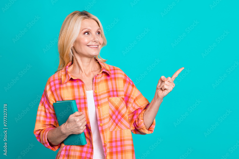 Portrait of smart woman straight hair dressed plaid shirt hold book directing empty space sale isolated on turquoise color background Portrait of smart woman straight hair dressed plaid shirt hold book directing empty space sale isolated on turquoise color background
