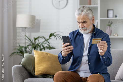 Senior man at home making a payment using smartphone