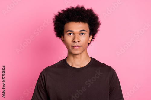 Portrait of young confident guy with chevelure hairstyle curly model in brown shirt no emotions isolated on pastel pink color background photo