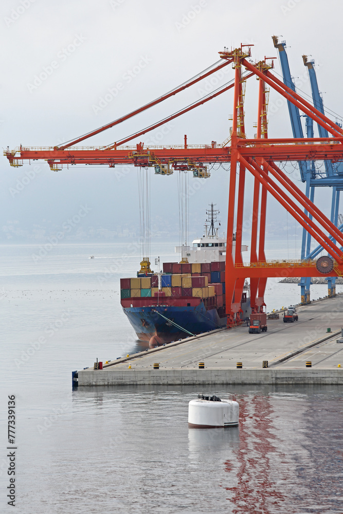 Naklejka premium Two Gantry Cranes Loading Cargo Ship at Container Terminal