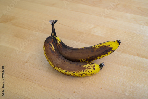 Brązowe, bardzo dojrzałe banany leżą na stole