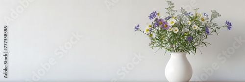 wildflowers in white vase on table on white wall background,   © Planetz
