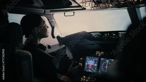 A woman pilot is flying in the cockpit. The pilot makes a sharp turn to the left photo