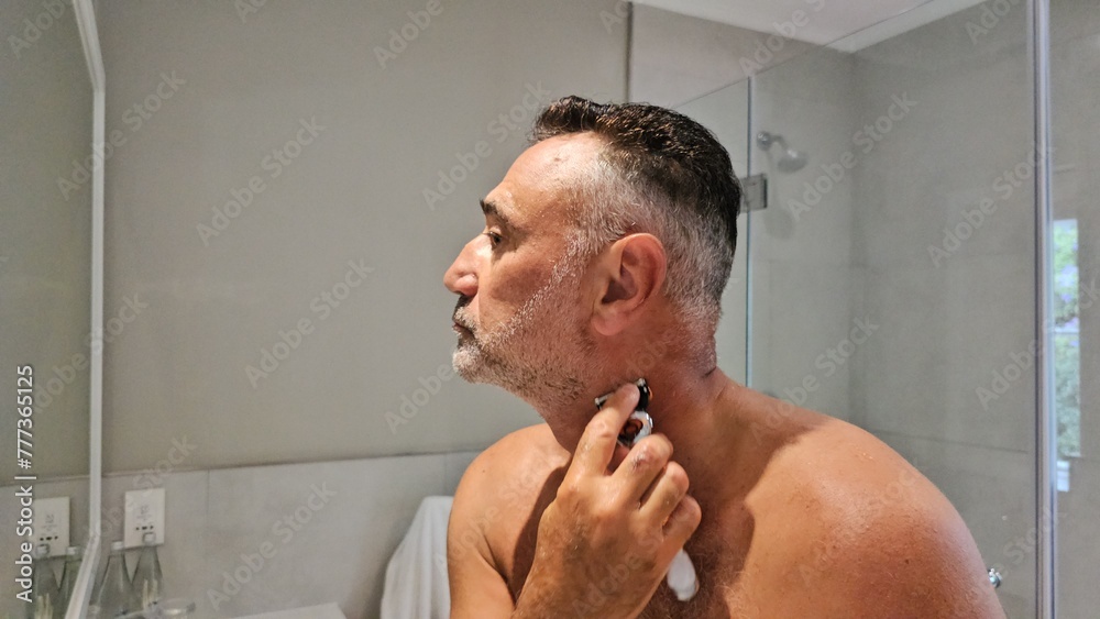 Fototapeta premium Man Shaving His Face in the Mirror
