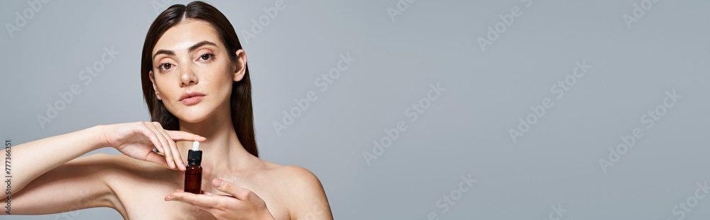 A young Caucasian woman with brunette hair holds a bottle of serum in her hands A young Caucasian woman with brunette hair holds a bottle of serum in her hands