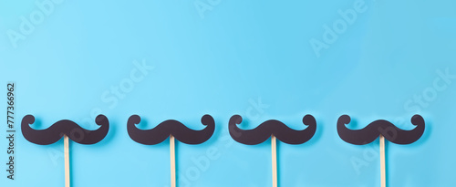 Paper black mustaches attach with wooden stick against blue background , November to raise awareness of men's health issues and a prostate cancer, Father's day, Dad, the best dad ever photo