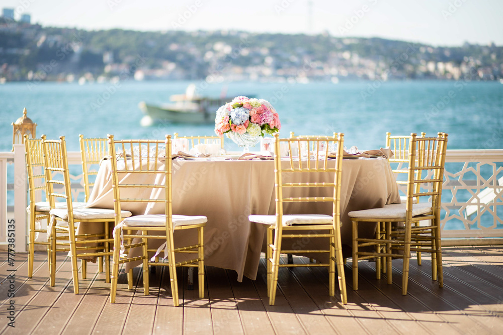 White color wedding table decorated with decorative and elegant for wedding. There are flowers, candles and serving plates on the wedding table.