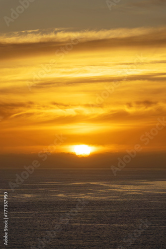 Orange sky with clouds on the ocean at sunset in Madeira island, Portugal