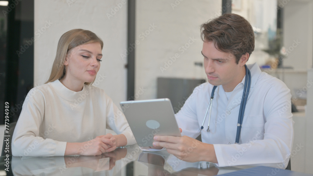 Male Doctor Discussing Treatment with Patient on Digital Tablet Male Doctor Discussing Treatment with Patient on Digital Tablet