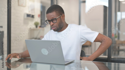 African American Man with Back Pain Working on Laptop