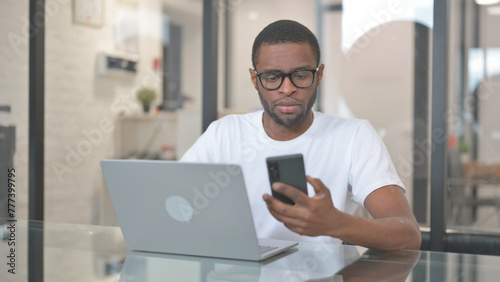 African American Man Working with Smartphone and Laptop