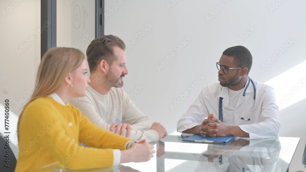 Young Couple Talking with Doctor in Clinic Young Couple Talking with Doctor in Clinic