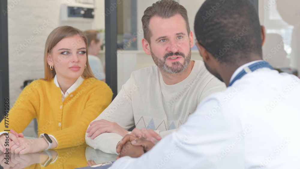 Obraz premium Close up of Young Couple Talking with Doctor