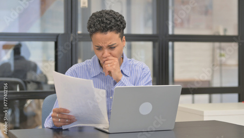 Mixed Race Woman Upset while Reading Contract while Using Laptop