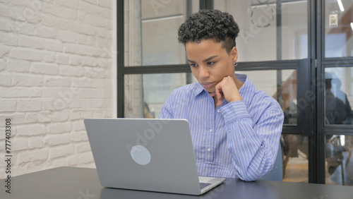 Pensive Young African Woman Brainstorming while at Work