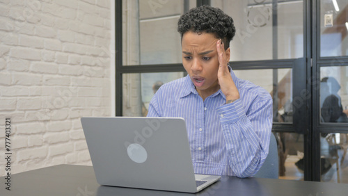 Young African Woman Shocked by Loss on Laptop