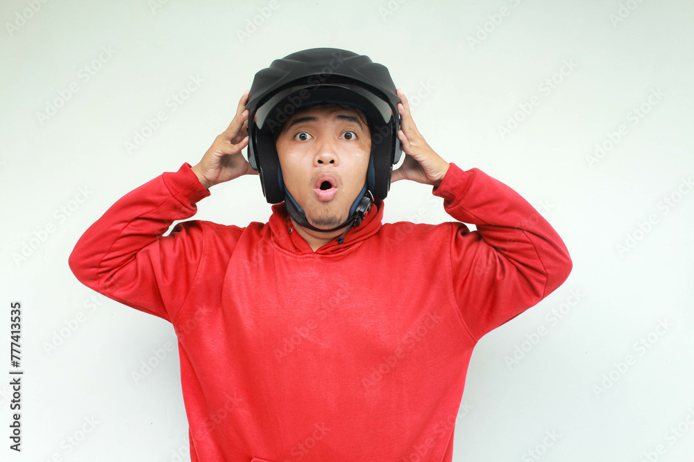 Young Asian man shocked gesture while wear a motorcycle helmet. Safety concept. Young Asian man shocked gesture while wear a motorcycle helmet. Safety concept.