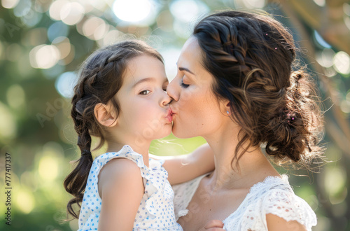 Beautiful young mother kissing her little daughter,