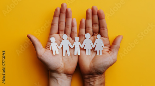 Hands holding paper cut-out figures on a bright yellow background, symbolizing unity and community support, Generative AI. Generative AI