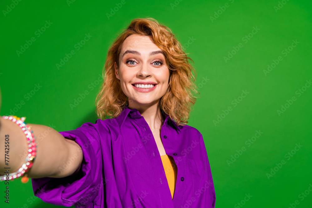 Photo portrait of pretty young girl take selfie toothy smile wear trendy purple outfit isolated on green color background Photo portrait of pretty young girl take selfie toothy smile wear trendy purple outfit isolated on green color background