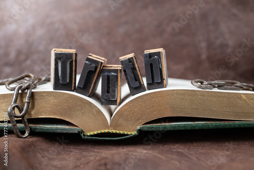 truth will set you free, still life concept with golden book and broken chains, soft focus close up