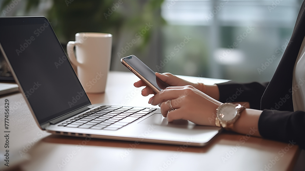 Closeup of business woman using and touching on mobile smart phone during working at home office with laptop computer on office table Closeup of business woman using and touching on mobile smart phone during working at home office with laptop computer on office table