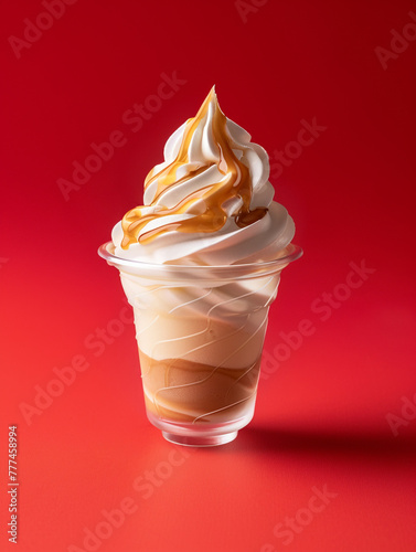 A glass of butterscotch ice cream with a swirl of cream on top. 