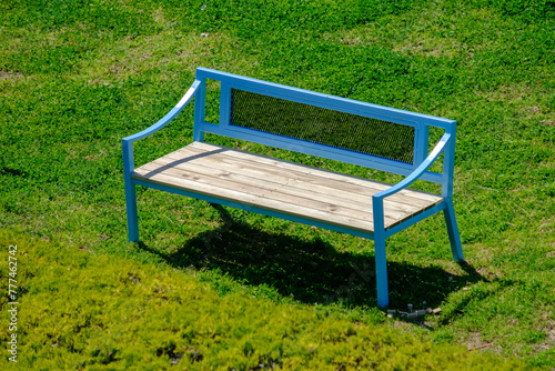 Blue bench on grass at a park. Suitable as a background