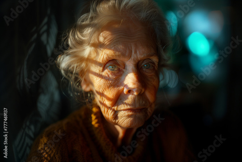 Serene and tranquil, an elderly woman's face is softly lit as she looks out of a window.