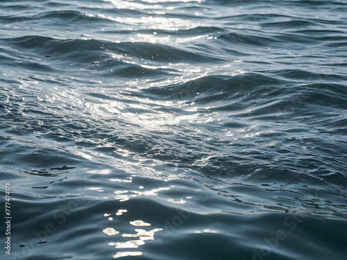 Blue sea water surface with sun reflection. Natural background and texture.