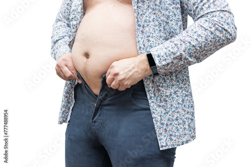 Overweight man with fat belly trying to fasten tight trousers, isolated on white background