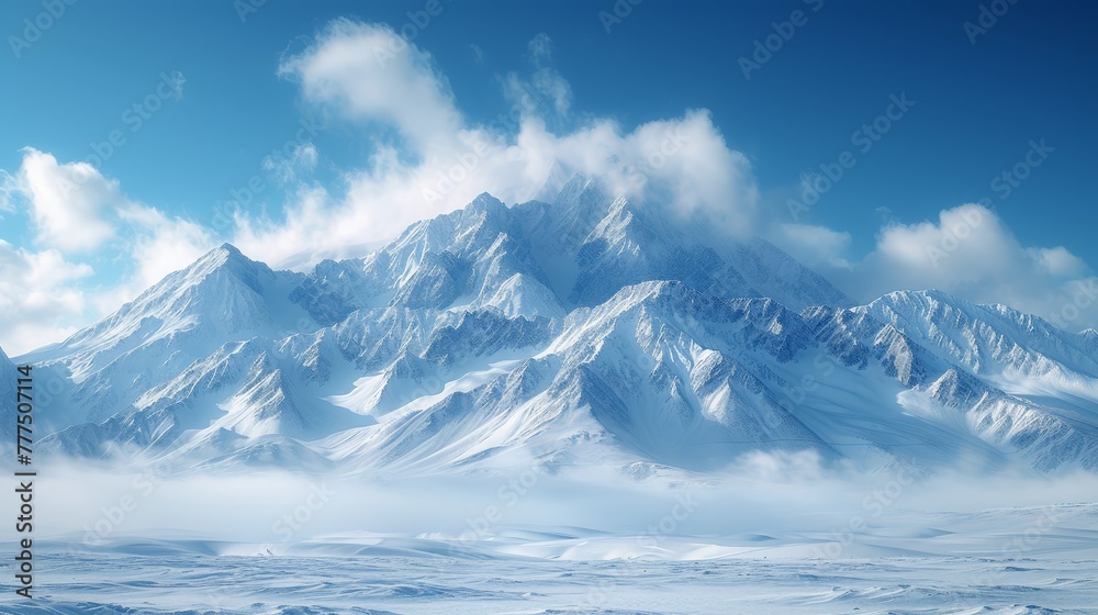   A mountain range, blanketed in snow, lies beneath a clear blue sky Soft, white clouds populate both the foreground and background