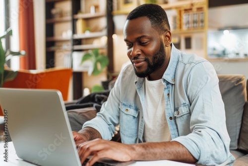 lively american man in his 30s, intently focusing on her laptop screen with an optimistic and determined look