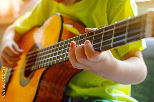 Young child in a vibrant lime green shirt learning to play the guitar