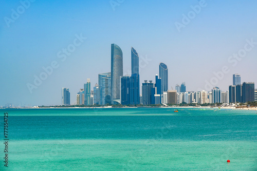 Panoramic view of Abu Dhabi with sea, waterfront Corniche, skyscrapers during summer sunny day in United Arab Emirates © Savvapanf Photo ©