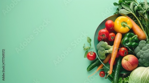 Assorted fresh vegetables and fruits on green background with copy space
