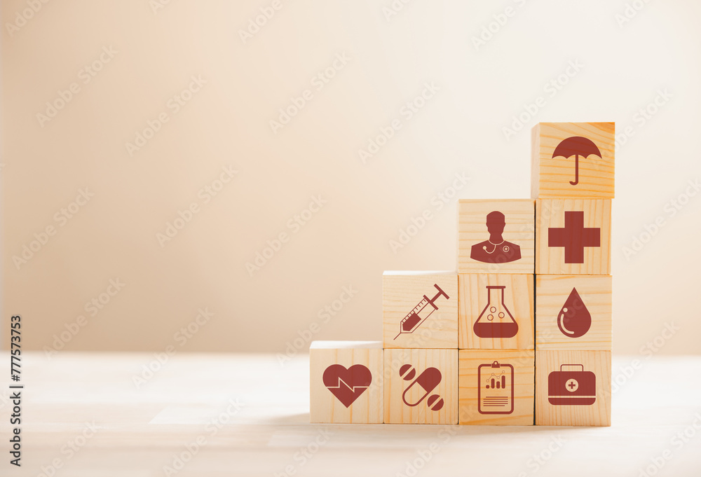 Wooden cubes stacked in a pyramid shape, embodying the healthcare and insurance concept. Atop, a medical insurance icon signifies protection. Blue background offers copyspace for Health Insurance idea - obrazy, fototapety, plakaty 