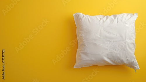 White pillow on bright yellow background, minimalistic home decor concept