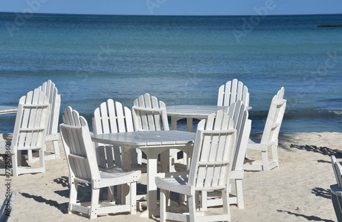 Scenic View of White Wooden Tables and Chairs on the Beach © dejavudesigns