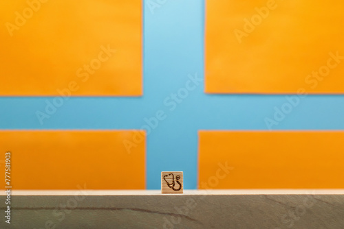 青い十字のマークをしたオレンジ色の背景に聴診器マークのブロックの正面