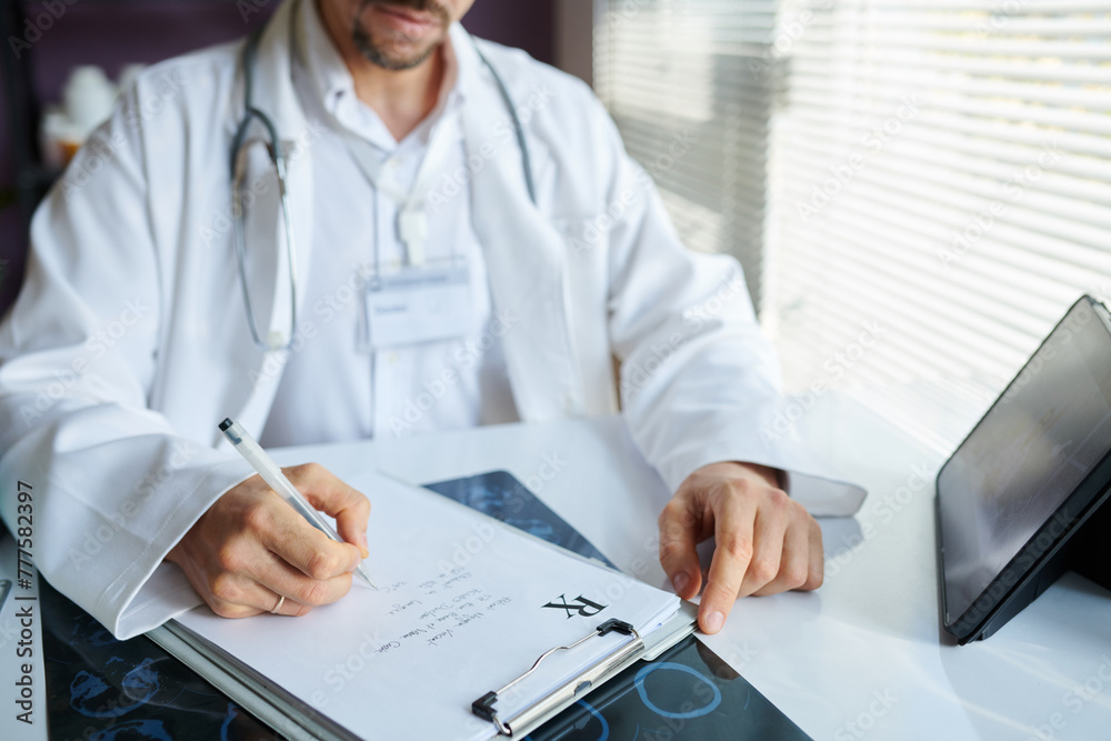 Fototapeta premium Hands of physician having online meeting with colleague when writing out prescription for patient