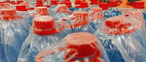 Plastic bottles with red caps for drinking water in the supermarket.
