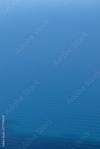 Relaxing background of small waves and ripples of vibrant blue water