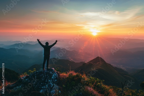 A person raising both hands at the top of the mountain , gaining success, top of the world ,achievement photo