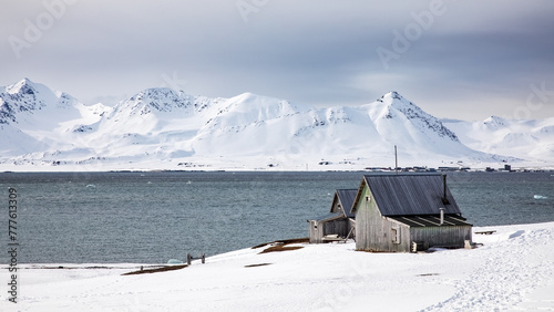 Abandoned miners cabins at Camp Mansfield, Svalbard, and panoramic view of the Kongsfjorden and surrounding mountains. photo