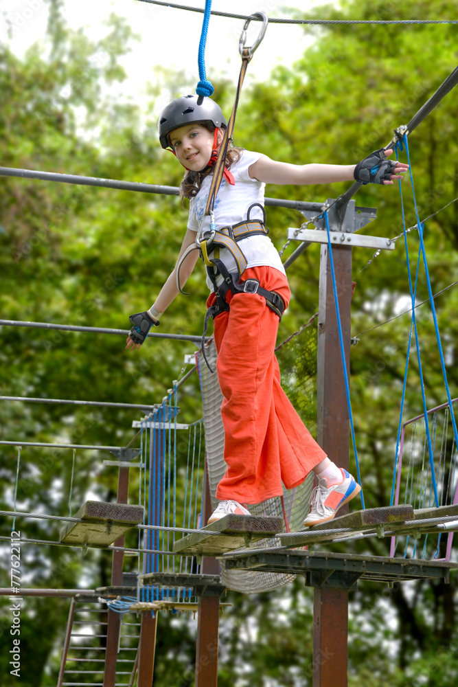 adventure climbing high wire park - people on course in mountain helmet