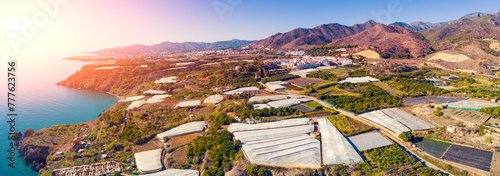 Panoramic view of the sea of greenhouses. Greenhouses in the south of Spain near Maro city, Nerja, Malaga, Spain. View from a drone. Horizontal banner